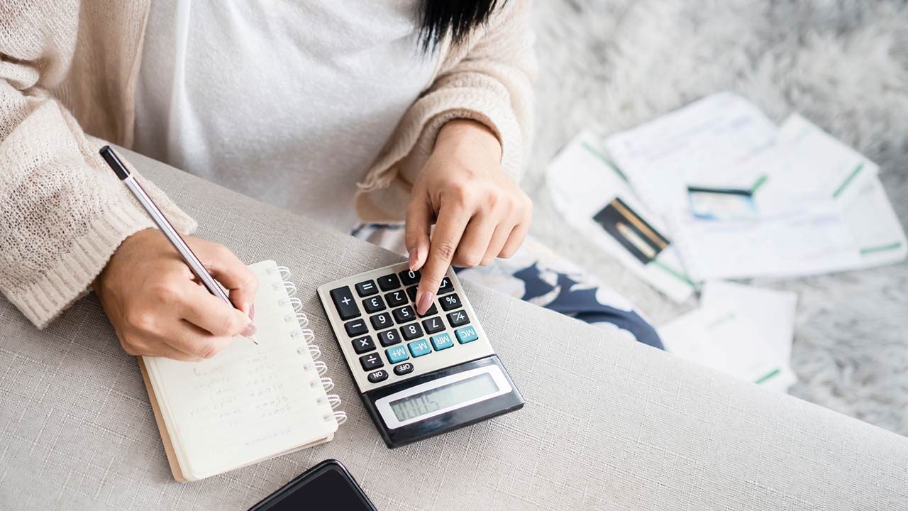 Image of a woman using a calculator to figure out personal finances