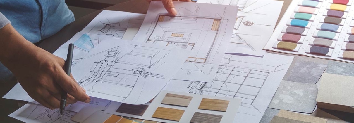 Interior designer working on hand drawing sketches on plan blueprints