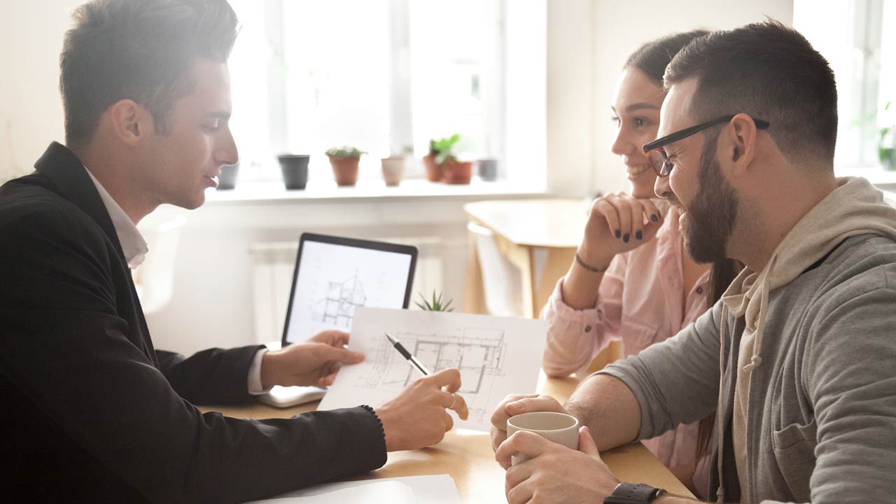 Interior designer discussing renovation ideas with happy couple at a meeting