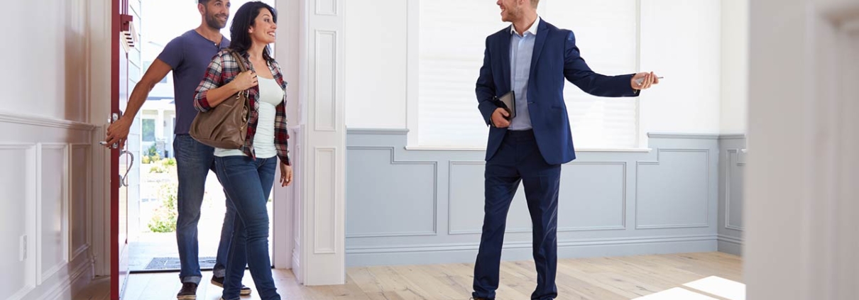 Real estate agent showing a couple around new home