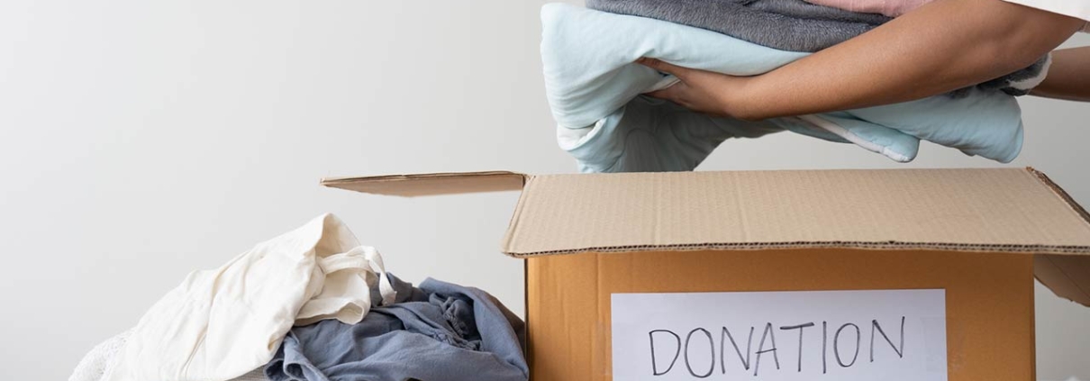 woman hands holding clothes putting in a donation box