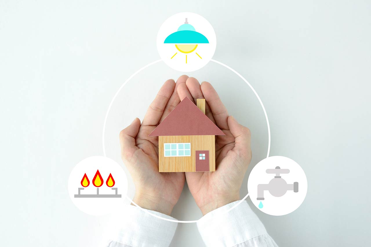 Human's hands and house object with gas, electricity and water icons