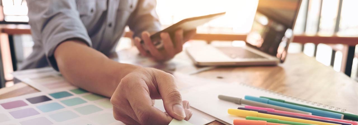 Man with laptop and paint swatches to select a new color
