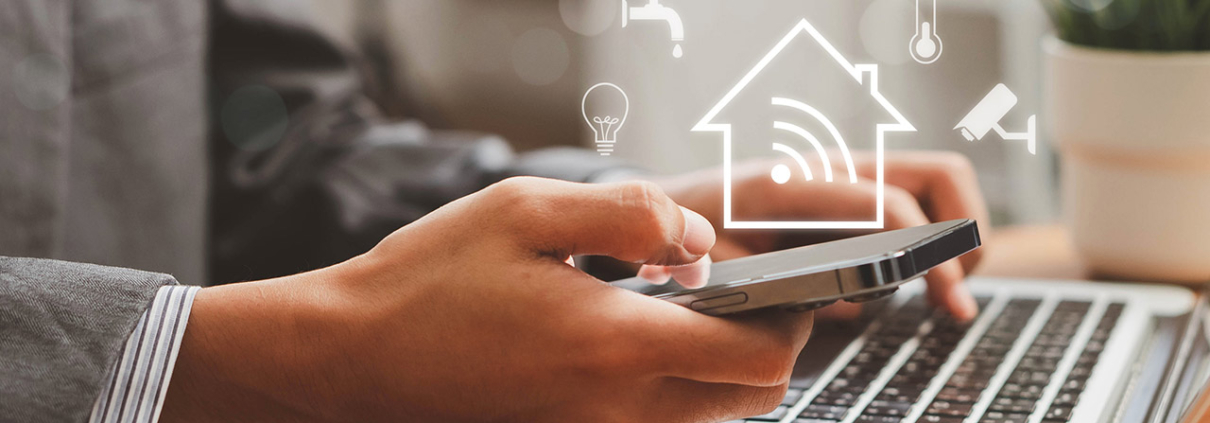 Person using a smart home app on a phone and laptop