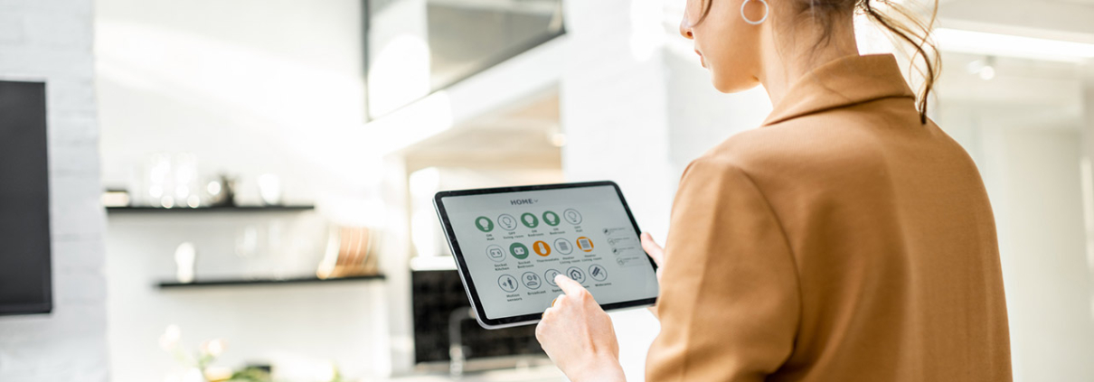 woman controlling smart home devices using a digital tablet with launched application in the white living room