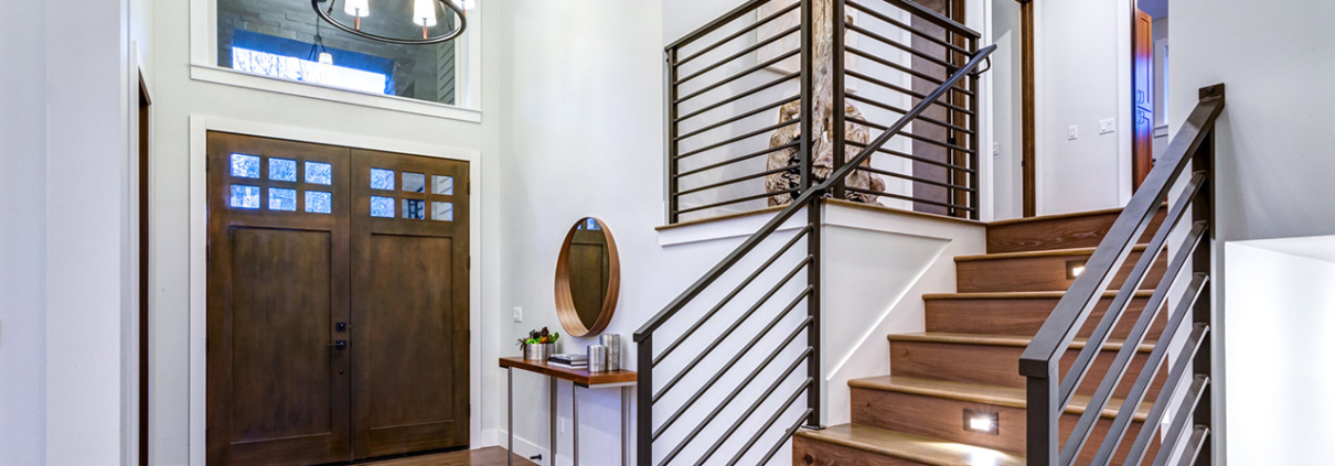 Chic entrance foyer with high ceiling and wide staircase with lights and contemporary railing