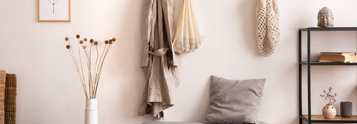 Cosy entryway with grey bench, coffee table, hanger and personal accessories stock photo