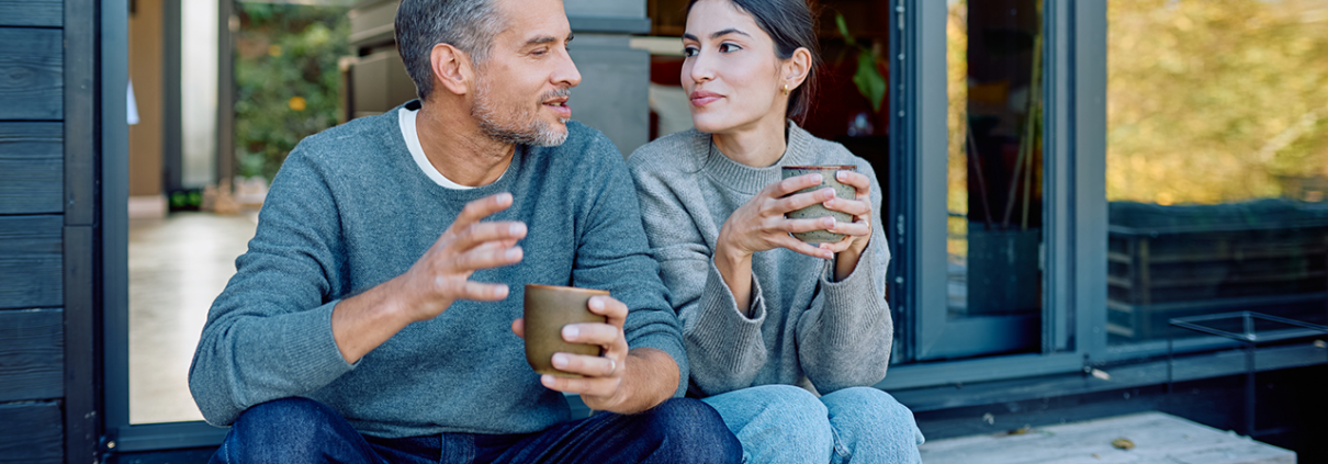 Couple relaxing and enjoying coffee while talking outdoors stock photo